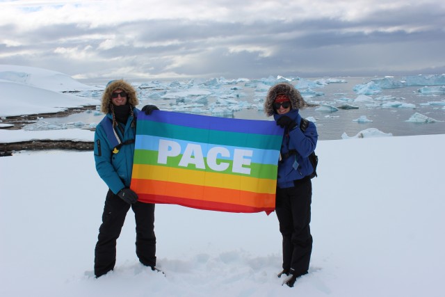 Chelsea and Ryan holding an Italian "Peace" flag on Antarctica