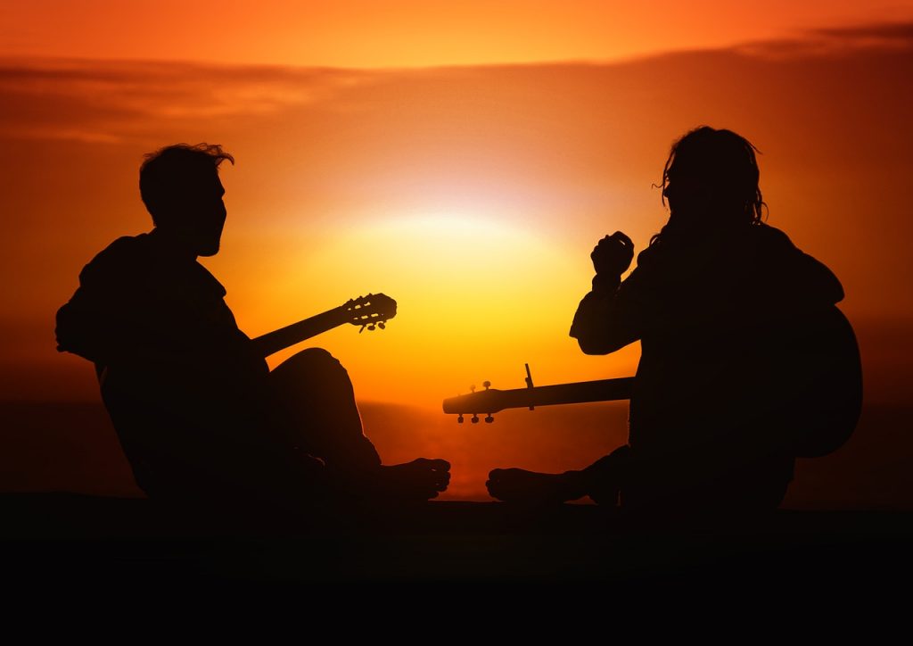 People playing the guitar on the beach